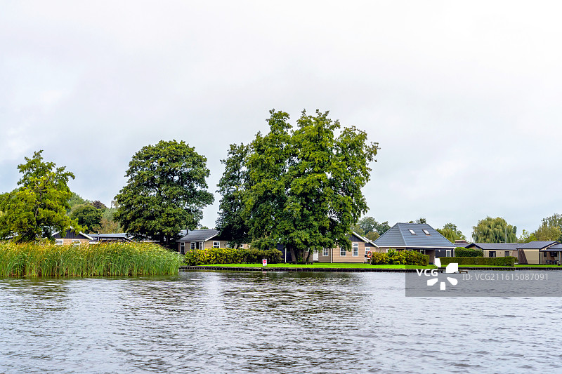 荷兰威尼斯羊角村  湖边的树木和建筑物顶着天空图片素材