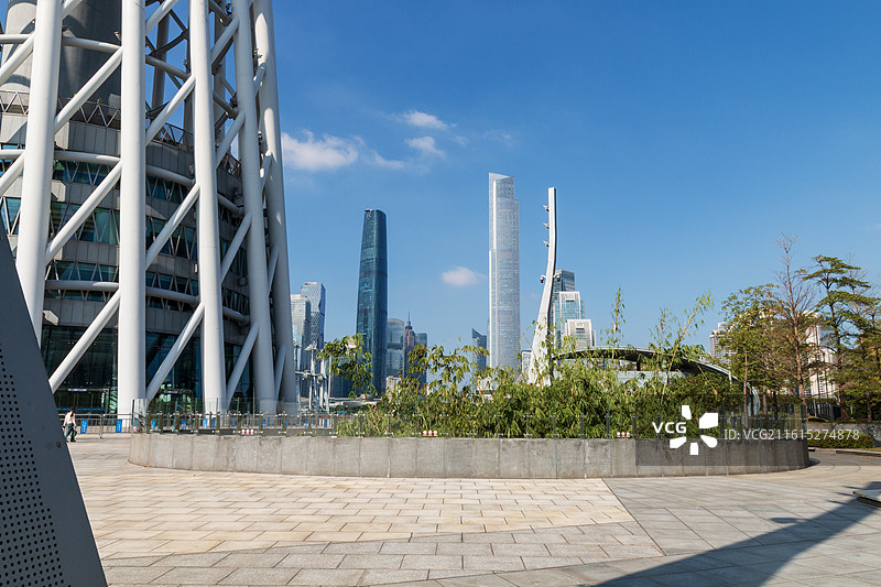 秋天蓝天白云低视角下的广州塔特写镜头和摩天大楼城市建筑风光图片素材