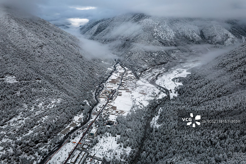 川西雪中山谷村庄图片素材