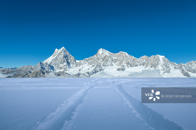雪山下的雪地上的车轮胎印，雪山背景，雪景，车轮胎印，汽车广告背景图，南迦巴瓦，库拉岗日图片素材