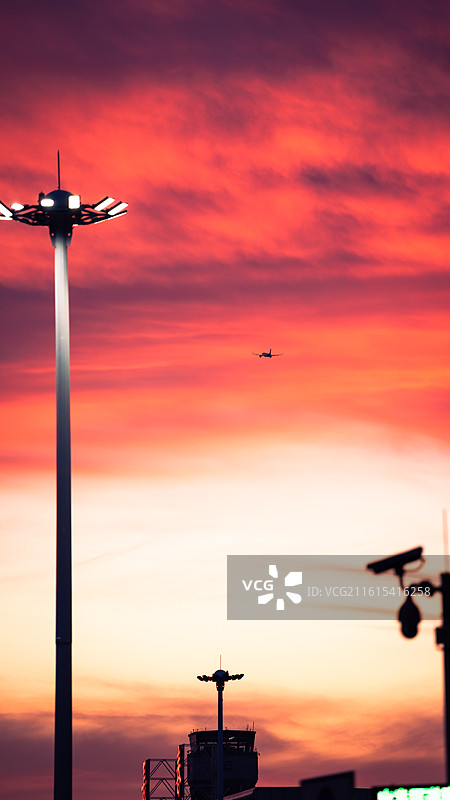长春机场，飞机飞过布满晚霞的天空图片素材
