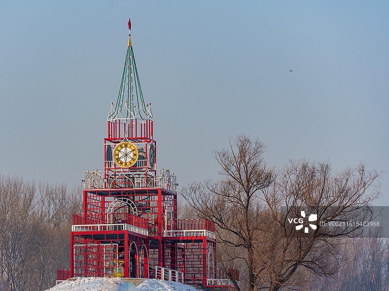 冬季的东北黑龙江哈尔滨伏尔加庄园，红框白饰俄式钟楼矗雪丘，彩顶时钟衬枯林绘冬日异域复古计时建筑景图片素材