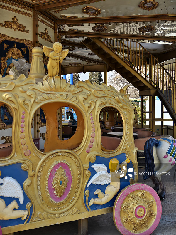 旋转木马细节：天使雕塑与金色雕花，童话游乐设施的精致工艺图片素材