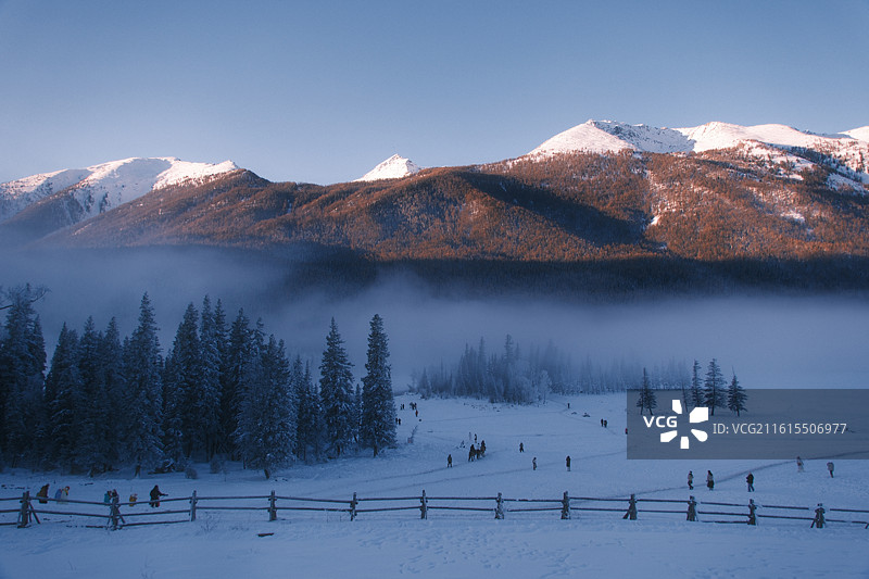 喀纳斯冬日：晨雾中的雪山雪原图片素材