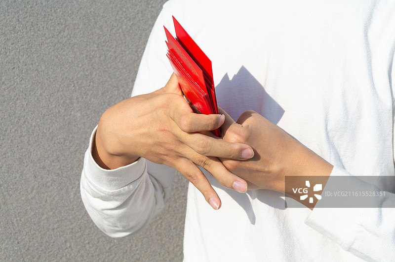 脑瘫患者手持无字款红包，展示农历新年的丰富习俗与生活态度。图片素材