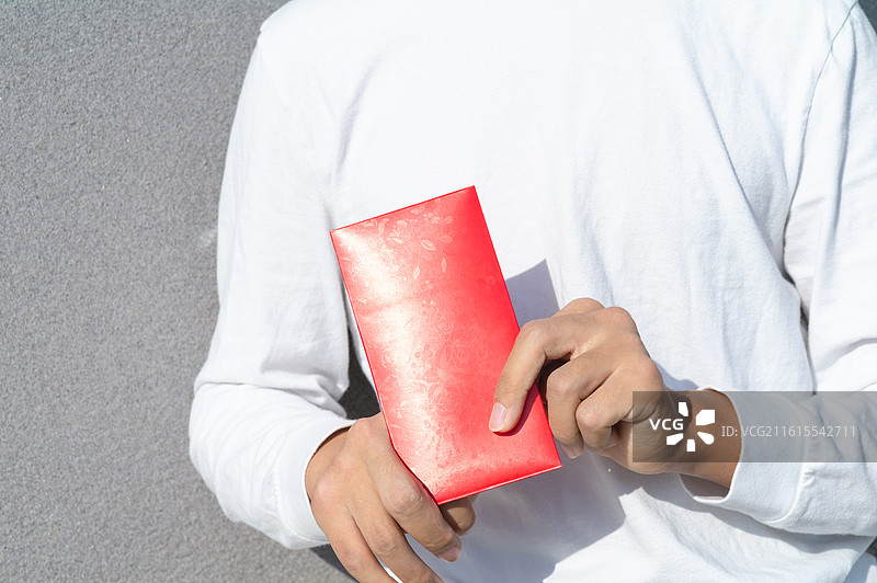 脑瘫患者手持无字款红包，展示农历新年的丰富习俗与生活态度。图片素材