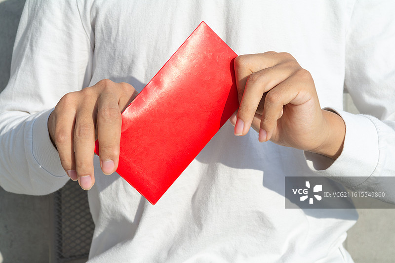 脑瘫患者手持无字款红包，展示农历新年的丰富习俗与生活态度。图片素材