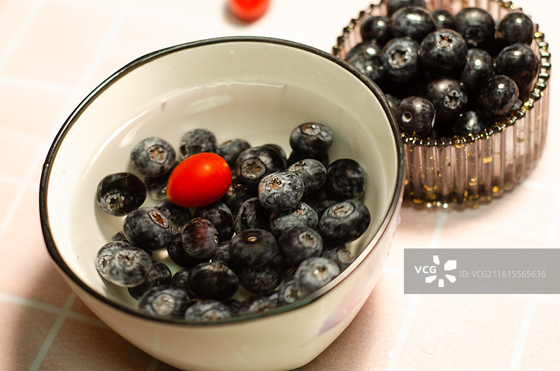 装有蓝莓和一颗小番茄的瓷碗特写图片素材