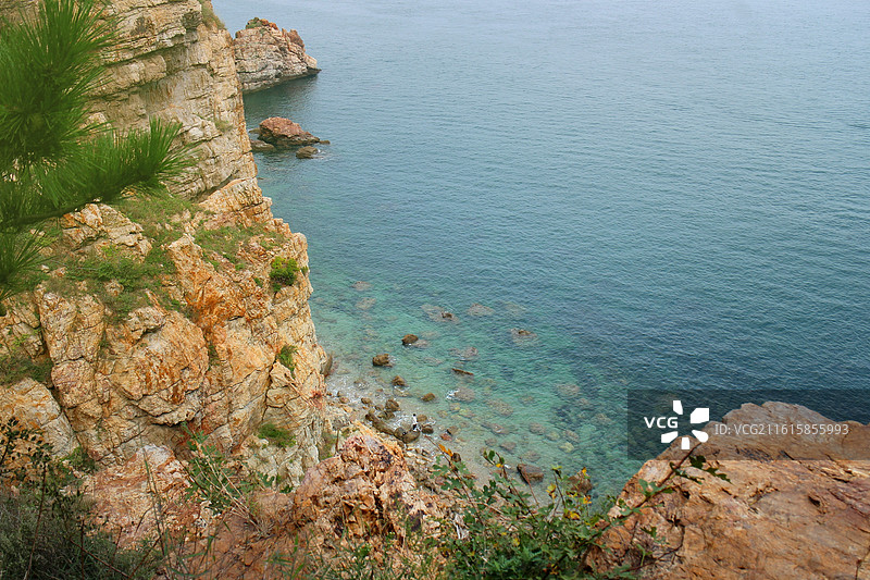 大连的海之韵公园的晨曦沙滩，藏于山与山相连的海湾间，海水呈现出迷人的蓝绿渐变，似果冻般晶莹剔透。图片素材