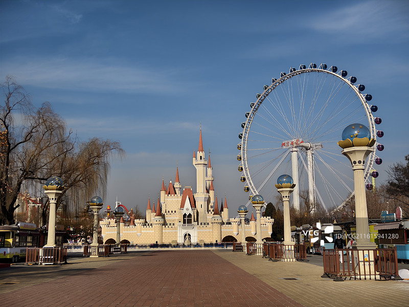 北京石景山游乐园：童话城堡与巨型摩天轮，冬日晴空下的欢乐地标图片素材