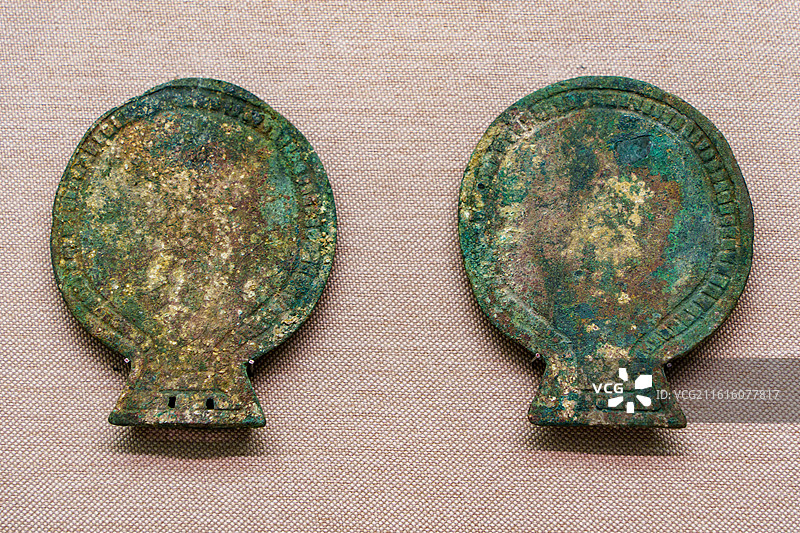 宁夏固原博物馆内，展陈着一对青铜椭圆形饰牌，锈迹斑驳，造型规整，尽显北方草原青铜器物的独特风貌图片素材