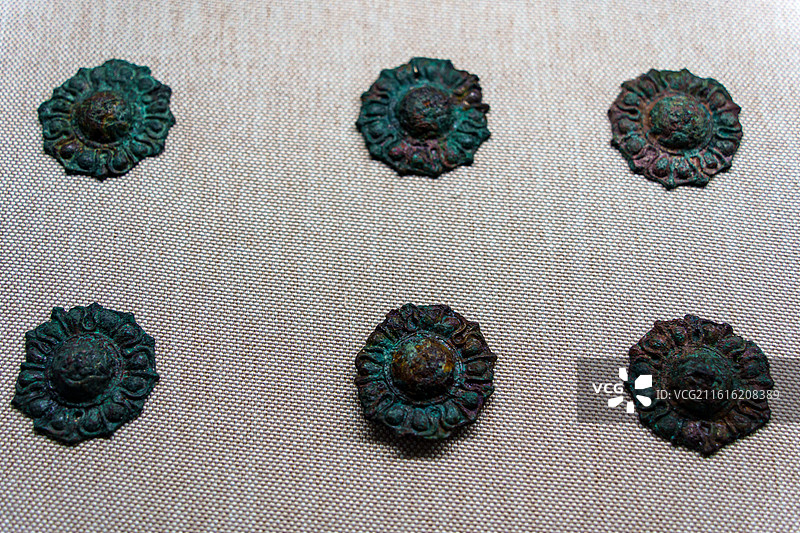 宁夏固原博物馆内，展陈着六件青铜花瓣形饰件，锈迹苍绿，造型精巧，尽显古代服饰构件的细腻工艺图片素材