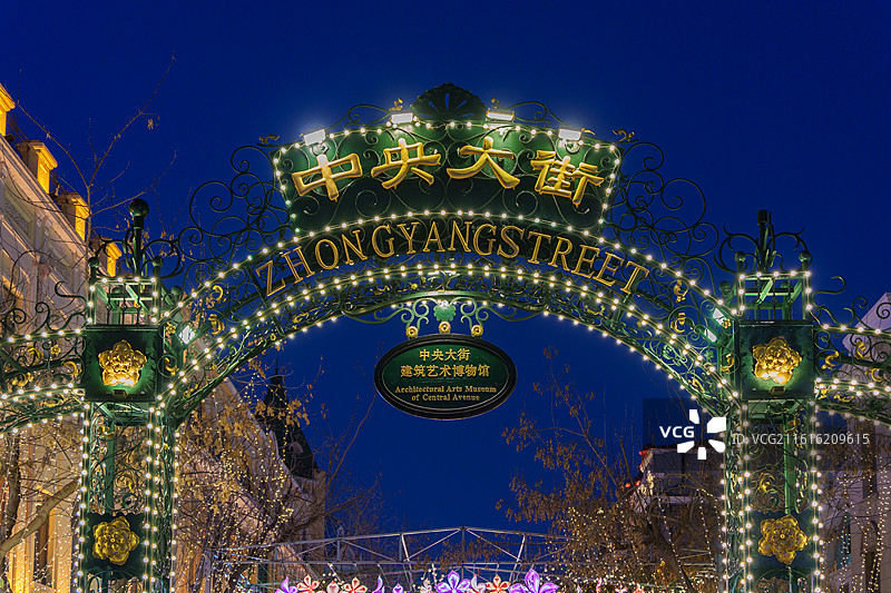 夜幕下的东北黑龙江哈尔滨中央大街口，铁艺拱门缀满灯串，鎏金字样在夜色里尽显欧式浪漫氛围图片素材