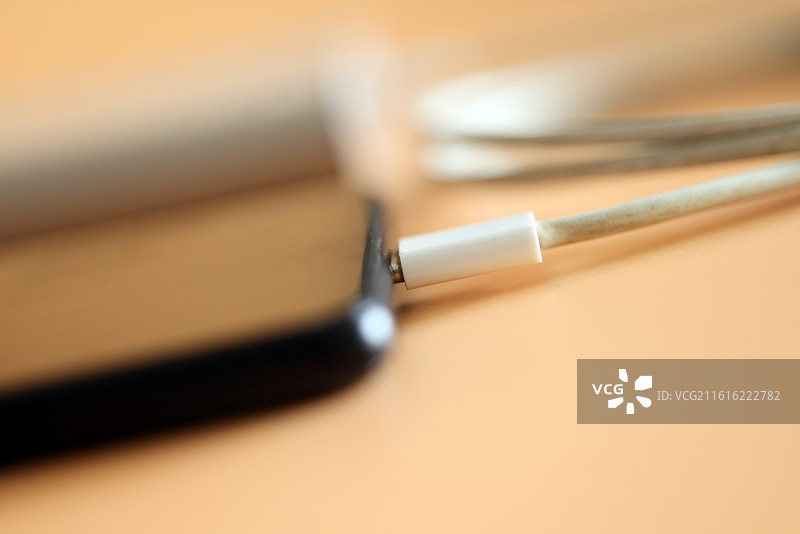 橙色背景下的智能手机和移动电源充电宝数据线特写镜头图片素材