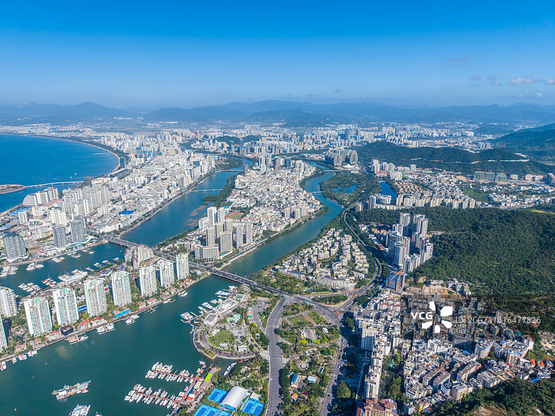 海南省三亚市大东海旅游区冬季沙滩海岸线上密密麻麻度假的中国与外国游客图片素材