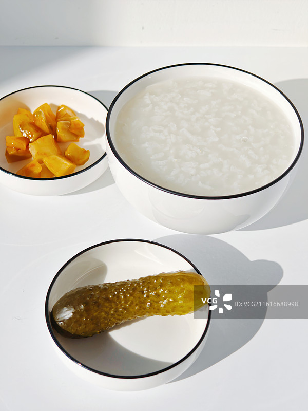 一顿早餐，一碗白粥搭配两个小菜，酸黄瓜和榨菜，一顿清淡的饮食，素食，一碗白米粥，清粥，养生，健康饮食图片素材