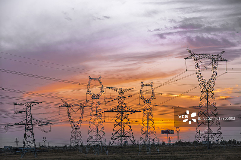 日落时青海海南州共和县塔拉滩光热发电基地高压电塔图片素材