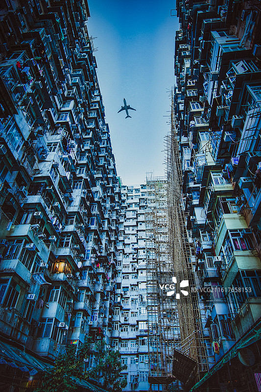 香港旧式高密度住宅楼群仰拍与掠过飞机图片素材