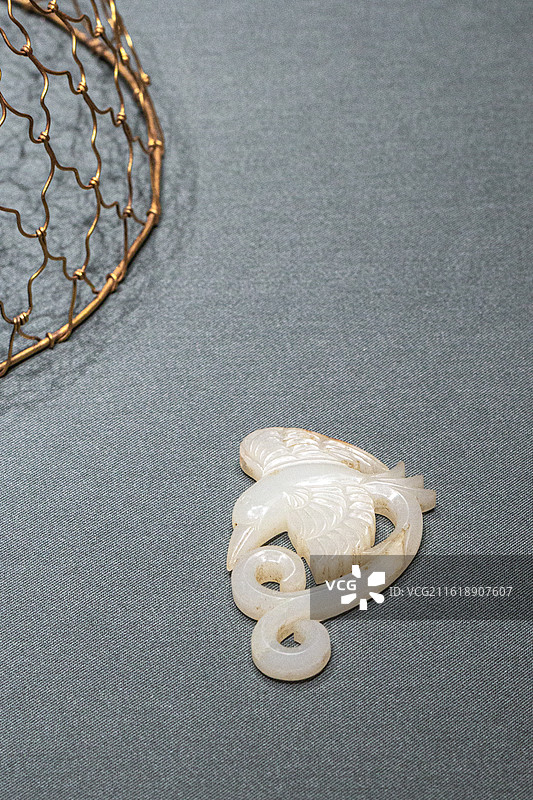 北京首都博物馆展出的金代 金代皇后舆服品镂刻白玉凤鸟衔绥带纹玉饰件和金丝编织网状凤冠金帽撑图片素材