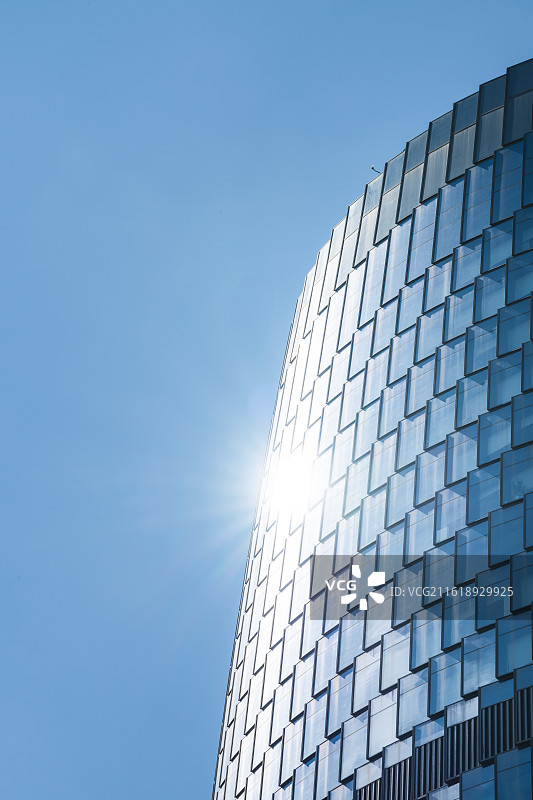 现代建筑玻璃幕墙特写-阳光耀眼星芒-商务科技背景图-竖拍天空留白图片素材