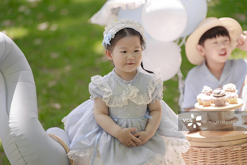 树林草坪野餐时生日小女孩与帅气小男孩享受蛋糕美食图片素材