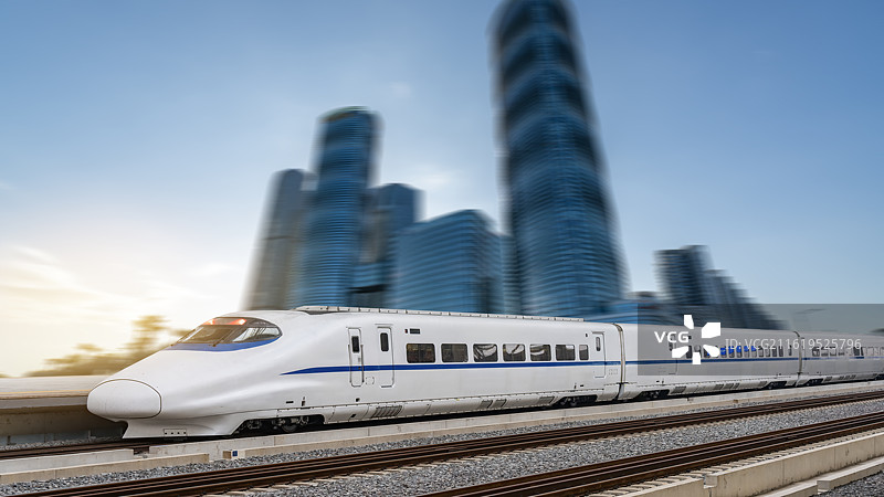 高速列车穿越模糊的现代城市建筑图片素材