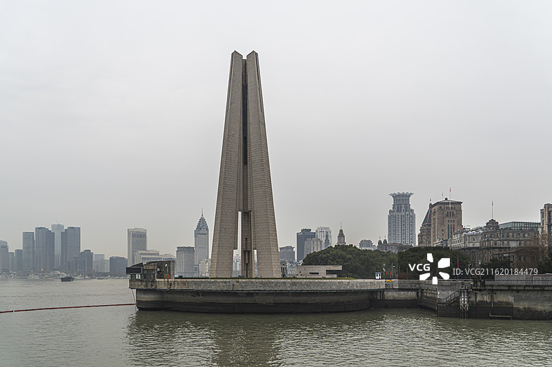 战争与和平-阴天的上海市人民英雄纪念塔与外滩建筑群与黄浦江图片素材