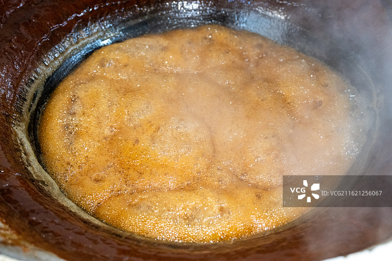 浙江金华义乌甘蔗榨糖加工厂正在热锅中加工的红糖浓缩糖浆图片素材