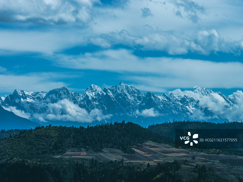 云南迪庆香格里拉的壮丽风光，山间云雾缭绕，如轻纱般为山脉增添了几分灵动与神秘。图片素材