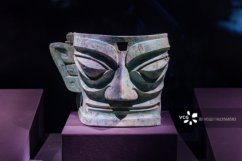 四川广汉三星堆博物馆内，青铜面具造型夸张，绿锈覆身，尽显古蜀文明的神秘与威严图片素材