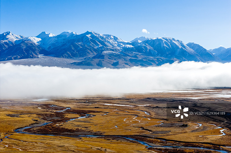 航拍蓝天下的新疆南疆木吉乡十八罗汉峰雪山和结冰的河流湿地平流雾云海风光图片素材