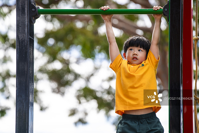 单杠肢体训练的活力男孩图片素材