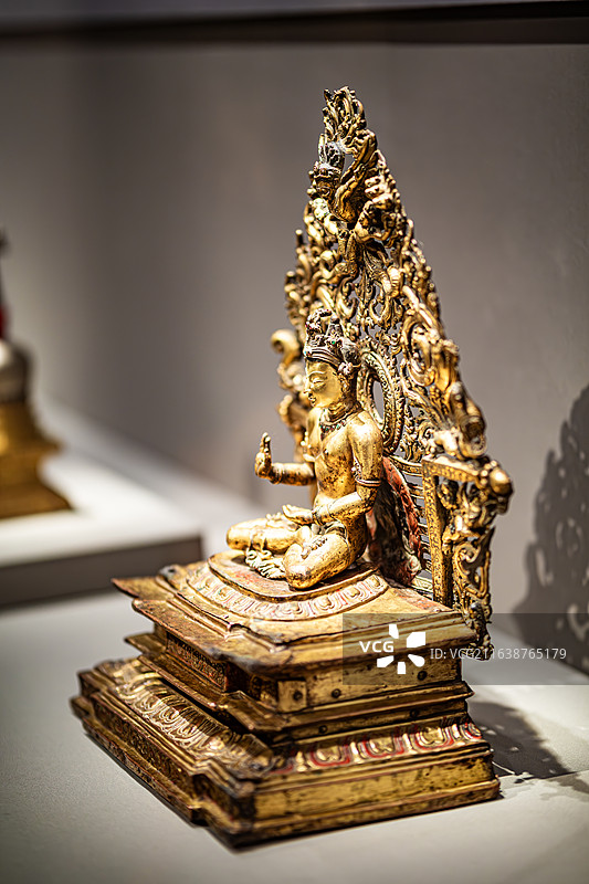 故宫博物院万法归一特展西藏萨迦寺藏14世纪红铜鎏金嵌宝石不空成就佛图片素材