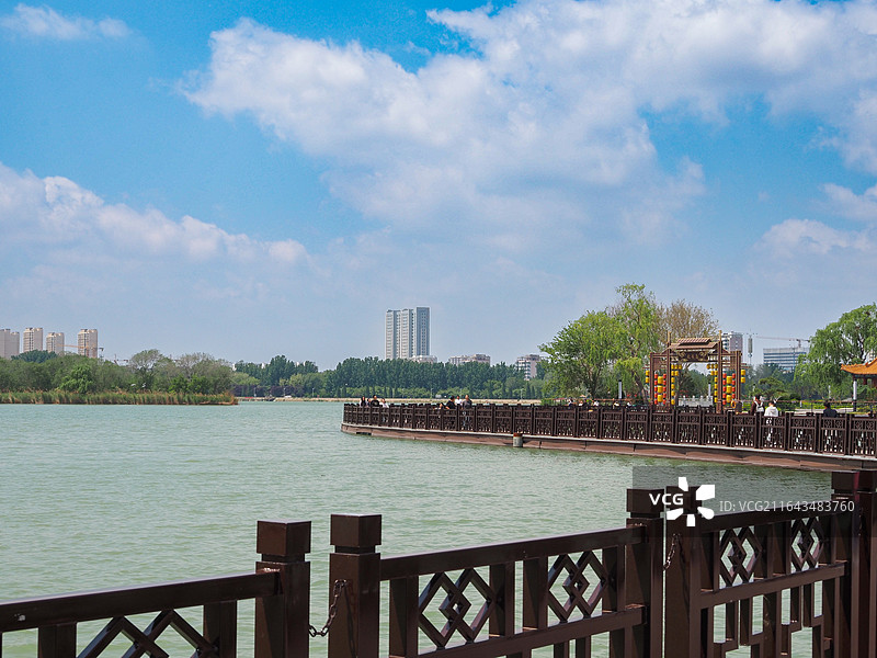 山东滨州蒲湖风景区湖水映衬下的现代城市建筑群图片素材