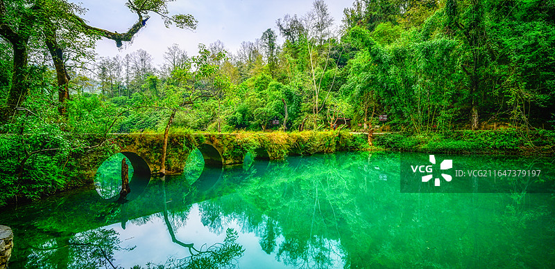 航拍贵州黔南荔波大小七孔景区全景，喀斯特地貌山水风光，碧绿湖水与古桥瀑布自然景观图片素材