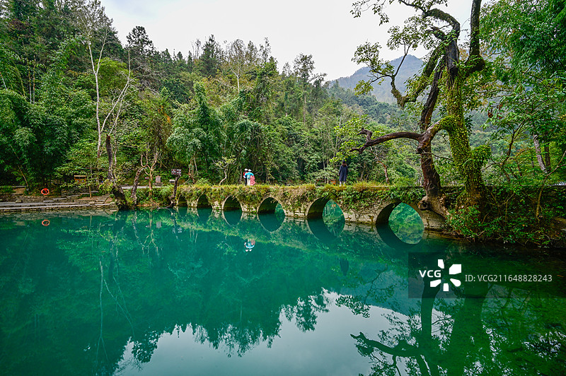 航拍贵州黔南荔波大小七孔景区全景，喀斯特地貌山水风光，碧绿湖水与古桥瀑布自然景观图片素材