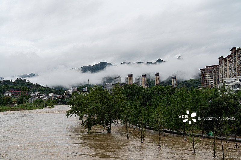 洪水淹没河岸树木城市建筑云雾山峦图片素材