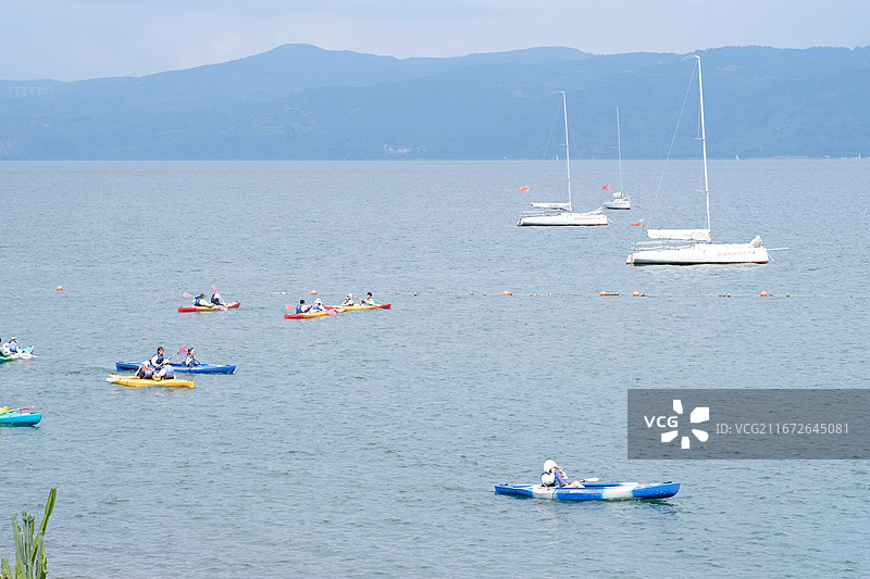 8月的云南抚仙湖，明星鱼洞景区，蓝色湖面上五颜六色的皮划艇图片素材