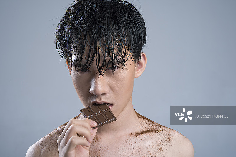 Young man eating chocolate图片素材