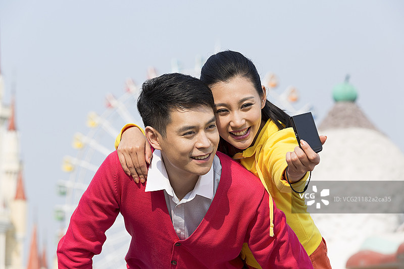 年轻情侣在游乐园自拍图片素材