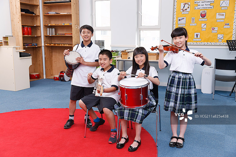 小学生正在拿着乐器演奏图片素材