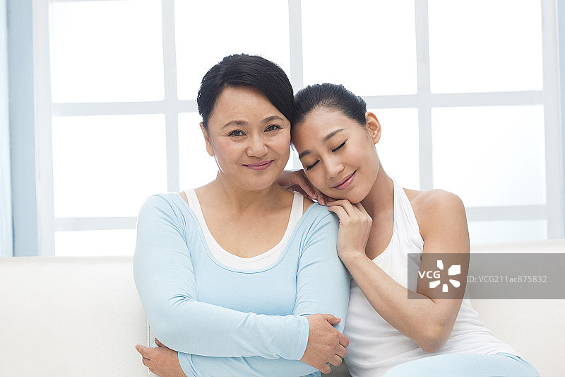 亲密的母女依偎在沙发上图片素材
