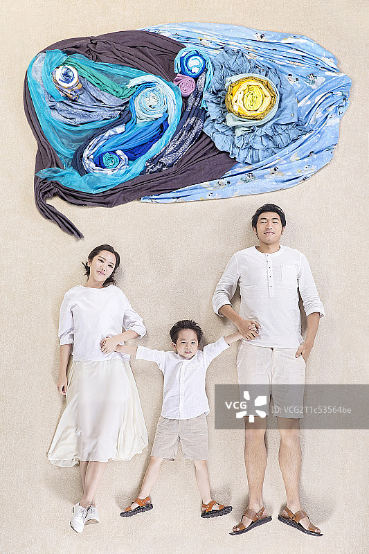 手拉手躺在地毯上的一家三口图片素材