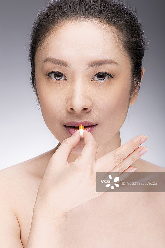 年轻女子吃胶囊图片素材