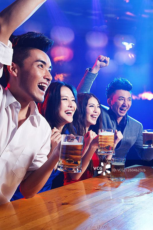 酒吧里喝酒欢呼的年轻人图片素材