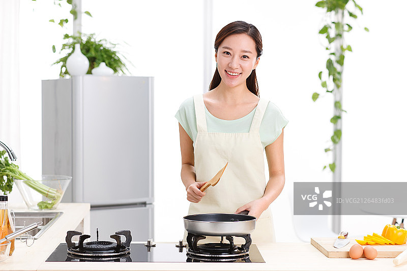 年轻女人在厨房做饭图片素材