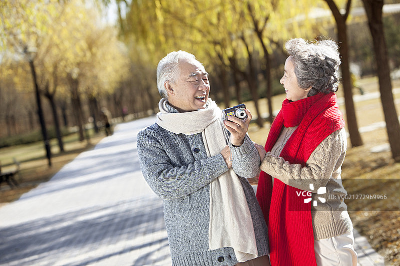 手拿相机拍照的老夫妻图片素材