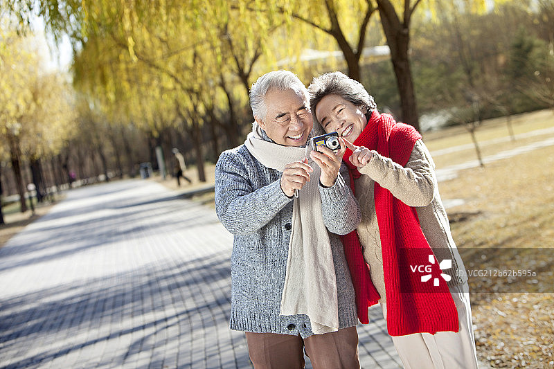 手拿相机拍照的老夫妻图片素材