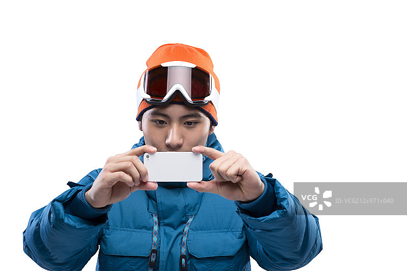 Young man taking selfie with smartphone during skiing图片素材