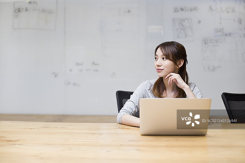 年轻女子在会议室使用笔记本电脑图片素材